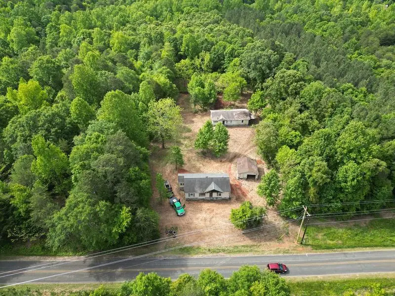Aerial view of a wooded property along the highway