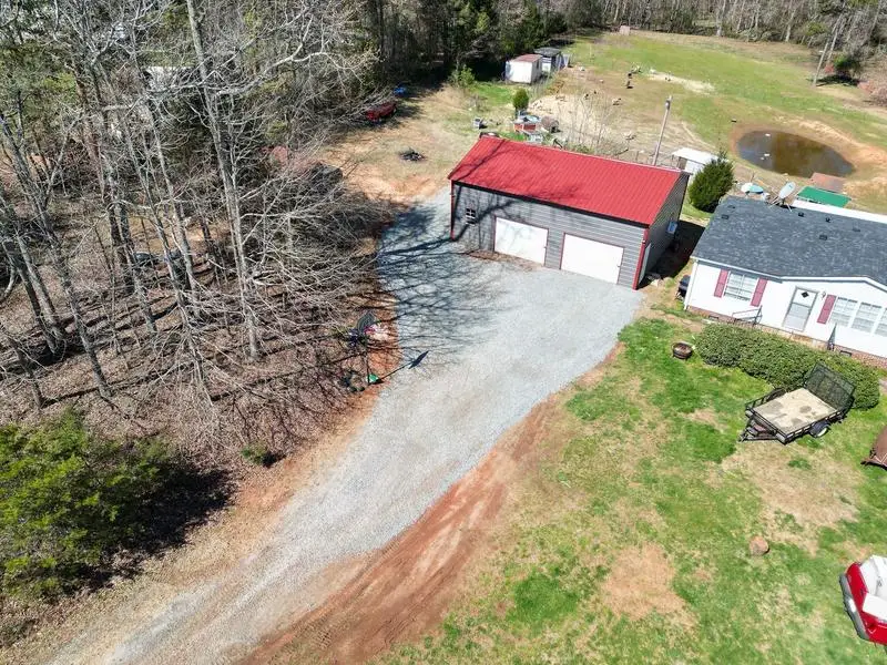 New gravel drive leading to a red metal building
